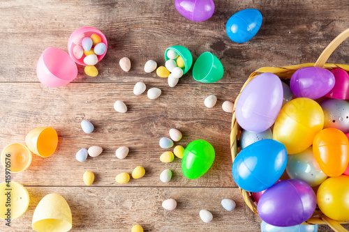 Canvas Print Flat lay image of plastic easter eggs being filled with chocolates before easter egg hunt