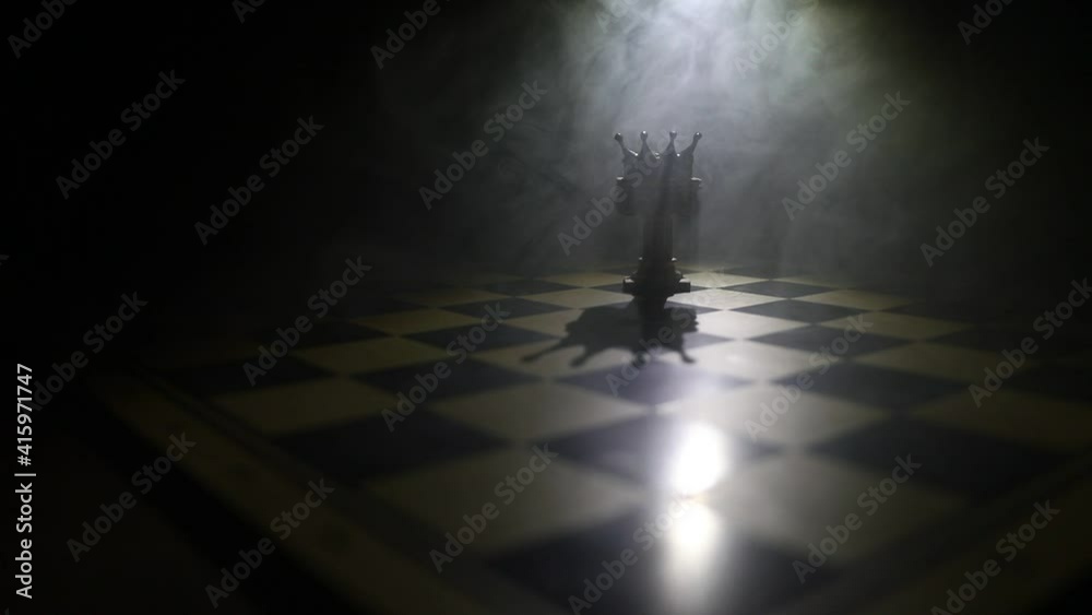 Beautiful crown miniature on chessboard. chess board game concept of business ideas and competition and strategy ideas concept. Chess figures on a dark background with smoke and fog. Selective focus