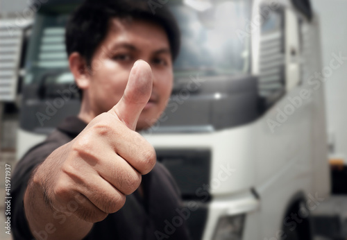 Close-up, Asian a truck driver giving thumb-up with semi truck.