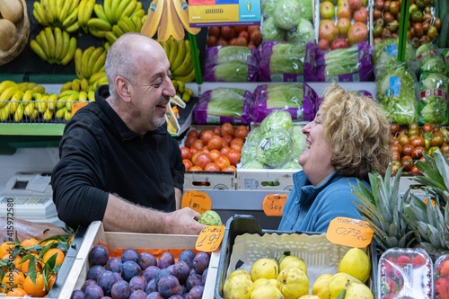 Two fruit sellers talking at the fruit store