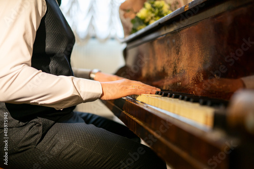 A wedding photo, a guy playing an old piano.