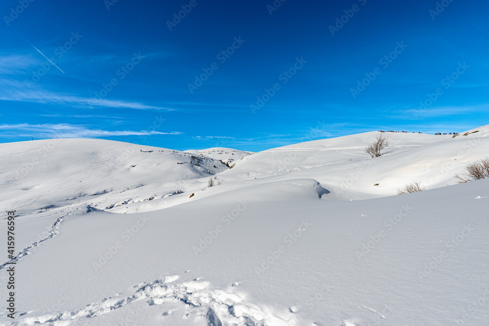 Snowy winter Landscape of the Lessinia Plateau (Altopiano della Lessinia) and Monte Tomba (Tomb Mountain), Regional Natural Park, near Malga San Giorgio, ski resort in Verona province, Veneto, Italy. Snowy winter Landscape of the Lessinia Plateau (Altopiano della Lessinia) and Monte Tomba (Tomb Mountain), Regional Natural Park, near Malga San Giorgio, ski resort in Verona province, Veneto, Italy.