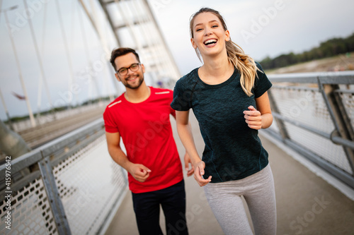 Early morning workout. Happy couple running across the bridge © NDABCREATIVITY