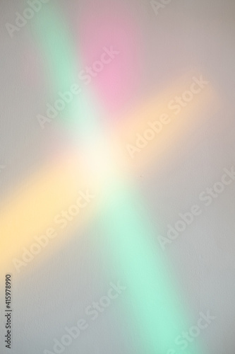 Rainbow lights. Abstract background. Gradient surface. Art poster. Colorful pink yellow green blur glowing rays overlay on neutral wall.