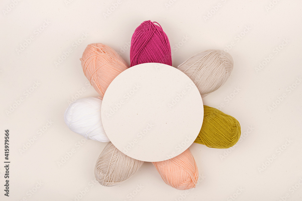 Balls of yarn is beige, burgundy, light pink and white.