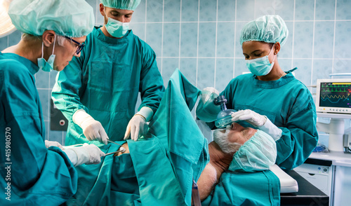 Group of surgeon doctor team at work in operating room.