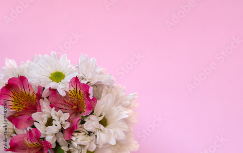 White chrysanthemum with pink alstroemeria in a bouquet on a pink background