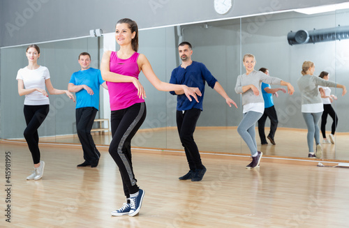 Cheerful young woman enjoying active dances in modern dance studio.