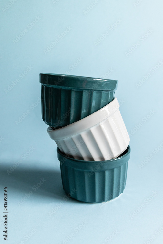 Ceramic Round Ramekins on a blue background. Vertical photo Ceramic Round Ramekins on a blue background. Vertical photo