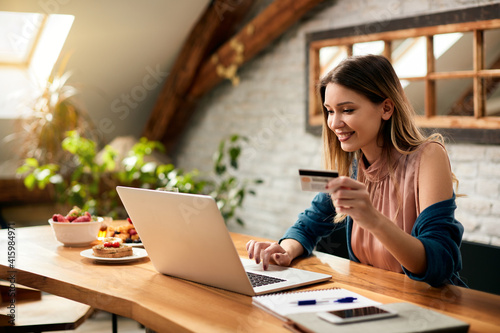 Young happy woman online shopping at home. photo