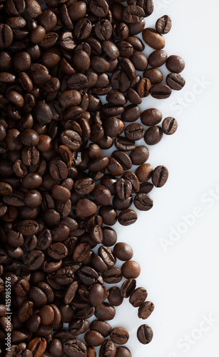 Natural background of roasted coffee beans on white surface..