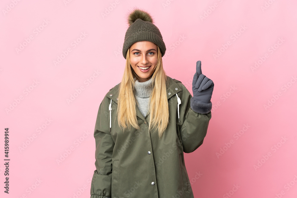 Young woman with winter hat isolated on pink background pointing up a great idea Young woman with winter hat isolated on pink background pointing up a great idea