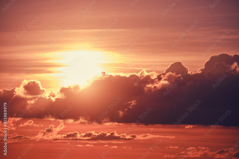 Obraz premium Evening cumulus clouds with the setting orange sun