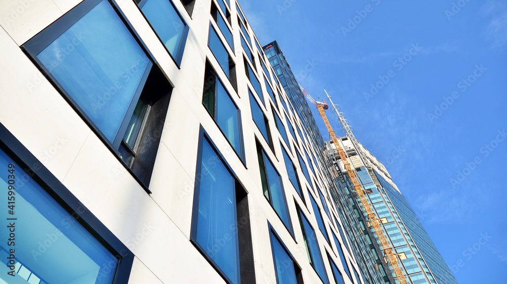 Fototapeta premium View of a skyscraper under construction. Modern architecture background. Building a high-rise building, the concept of real estate construction. 