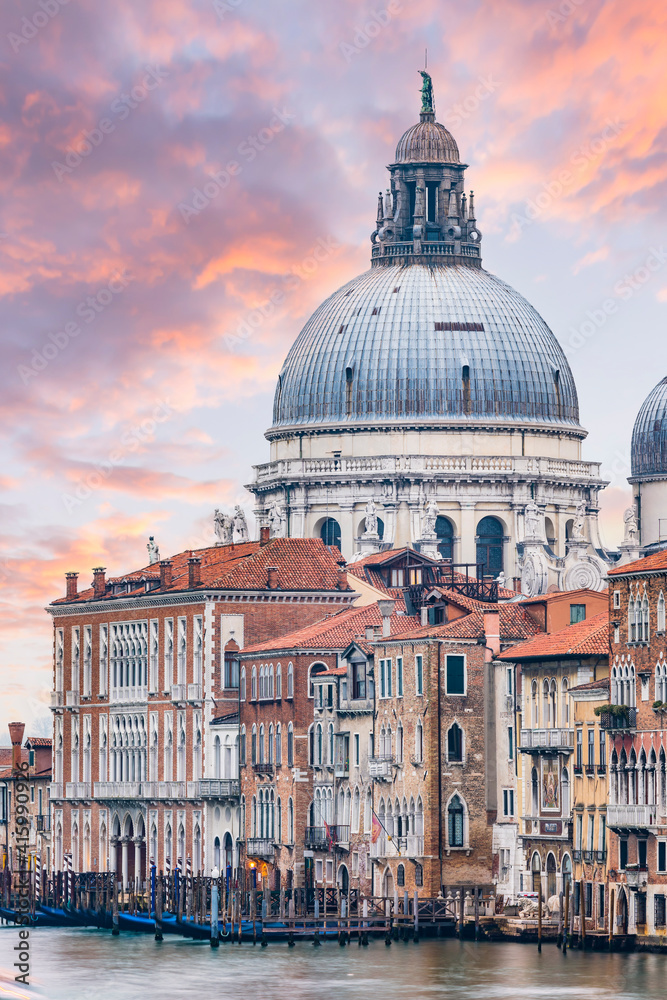 Stunning view of the Venice skyline with the Grand Canal and Basilica Santa Maria Della Salute in the distance during a dramatic sunrise. Picture taken from Ponte Dell’ Accademia.