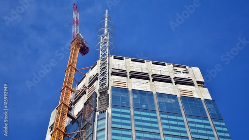 View of a skyscraper under construction. Modern architecture background. Building a high-rise building, the concept of real estate construction. 