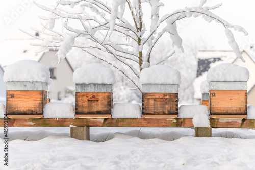 Beehives in apiary covered with snow in wintertime