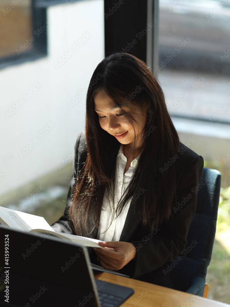 Fototapeta premium Businesswoman working with document file and digital tablet on coffee table