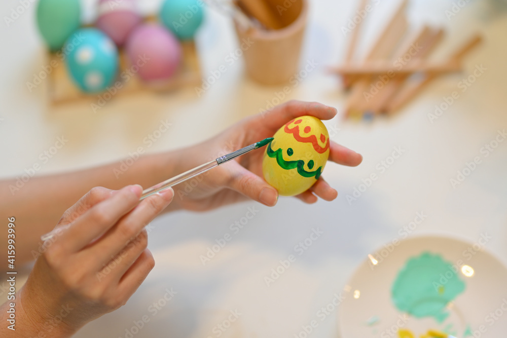 Female painting Easter egg, preparing for Easter Festival at home