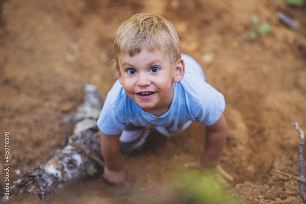 cute happy blond boy playing in ground outside, childhood concept cute happy blond boy playing in ground outside, childhood concept