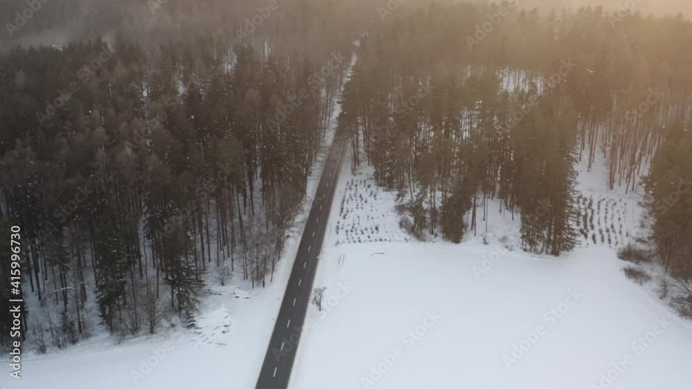 Aerial Shot Of Road In Beautiful Mountain Forest, Snow Covered During Winter At Sunrise Aerial Shot Of Road In Beautiful Mountain Forest, Snow Covered During Winter At Sunrise
