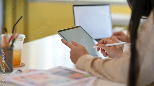 Female office worker hand working mock up digital tablet with stylus pen in office room