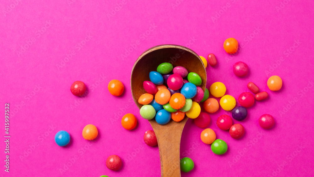 Obraz premium multicolored candy set with a wooden spoon