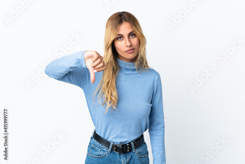 Young blonde Uruguayan woman over isolated background showing thumb down with negative expression © luismolinero