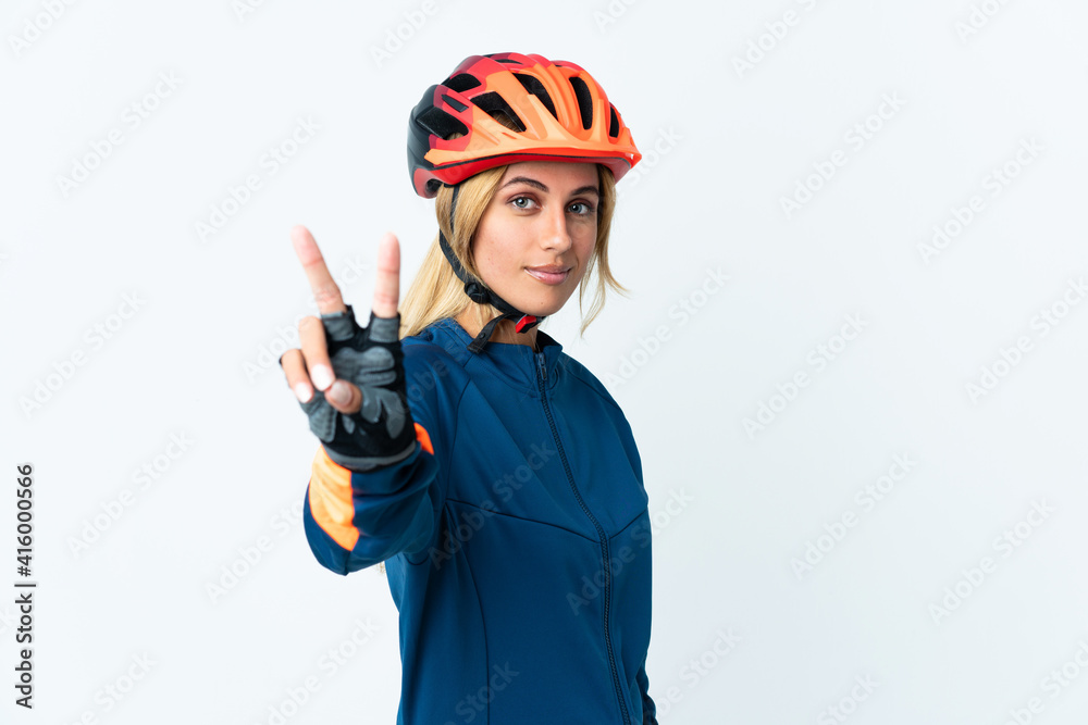 Young blonde Uruguayan cyclist woman isolated on background smiling and showing victory sign Young blonde Uruguayan cyclist woman isolated on background smiling and showing victory sign
