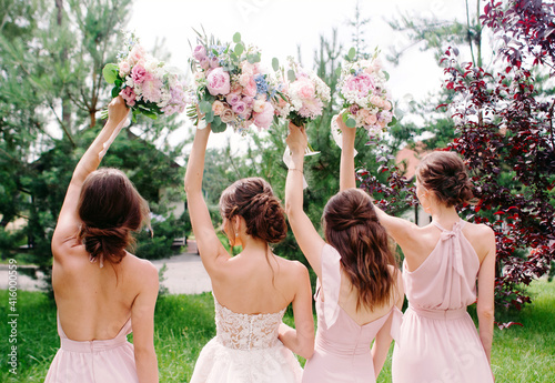 Wedding bouquets. Bridesmaid's bouquets. Bride with bridesmaids in dust pink dresses have fun in wedding day. Happy marriage and wedding party concept.