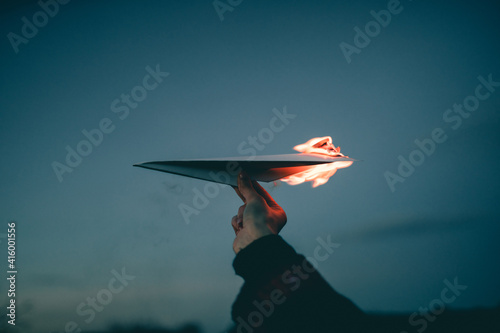 Bild auf Leinwand Human hand with burning paper airplane in the sky
