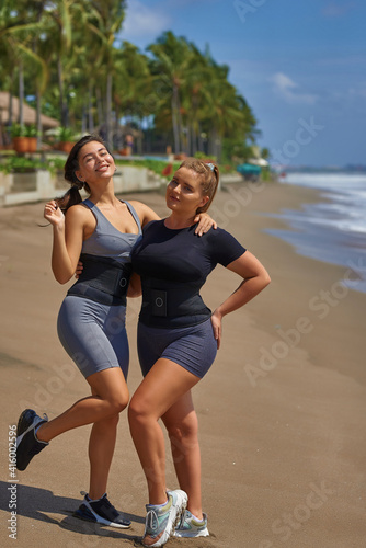 Two girls on the beach in sweat belt.