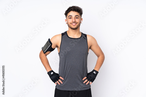 Sport Arabian man isolated on white background posing with arms at hip and smiling