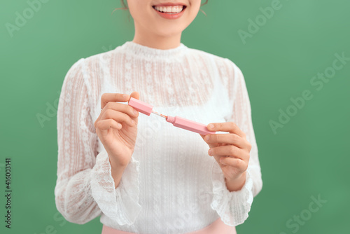 Woman with lip gloss. Photo of woman with perfect makeup on green background. Beauty concept photo