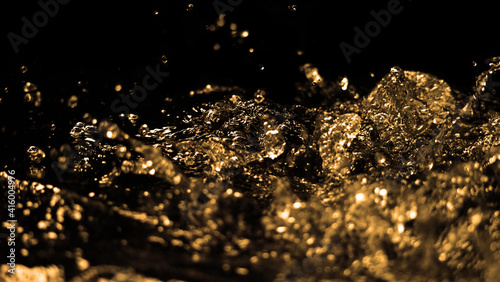 Hi speed close up images of oil liquid from diesel gasoline splashing and moving up to the air on black background. Power of fuel liquid that active and powerful. studio shot premium gold color tone. 