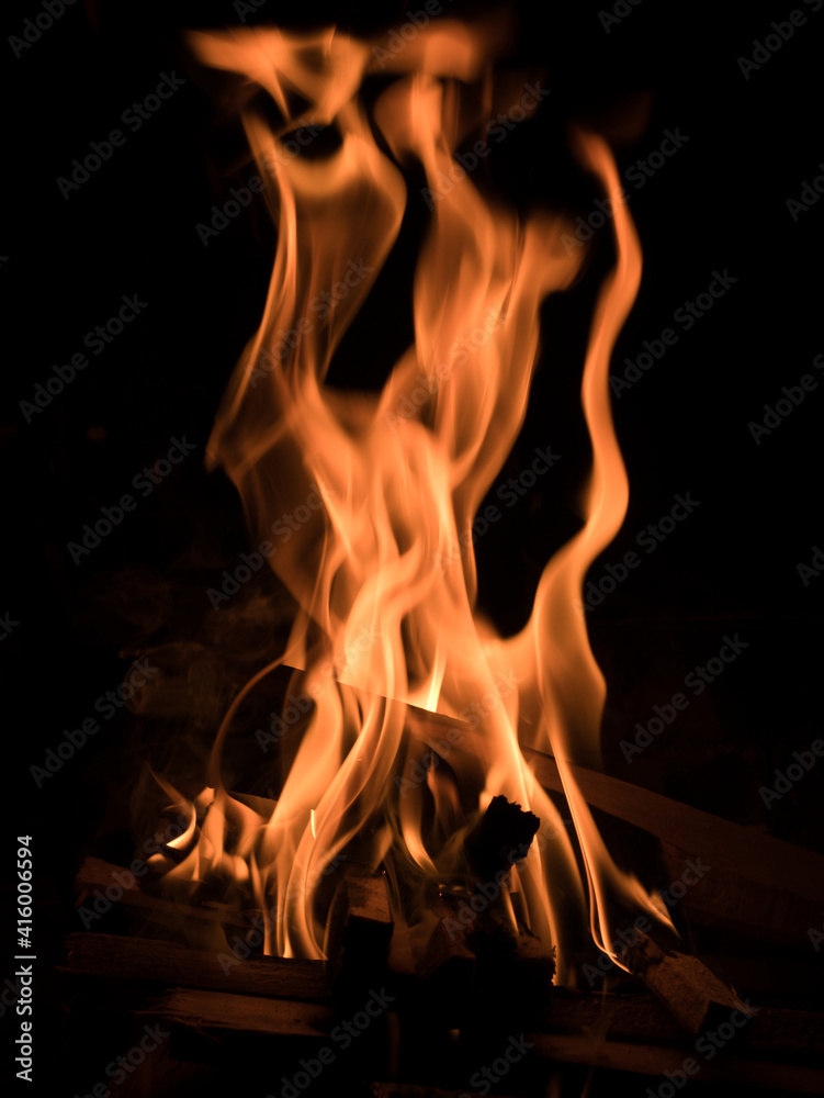 Burning wood and blazing flames against a black background Burning wood and blazing flames against a black background