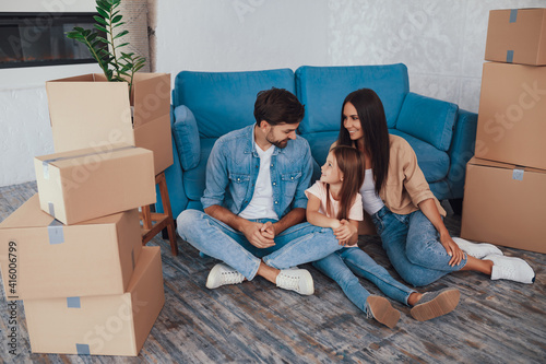 Excited young family posing between boxes in new appartment © Afshar Tetyana