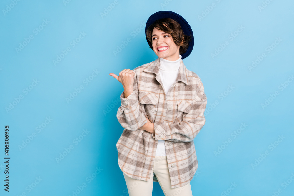 Photo of optimistic nice lady stand look point empty space wear headwear shirt isolated on teal color background Photo of optimistic nice lady stand look point empty space wear headwear shirt isolated on teal color background