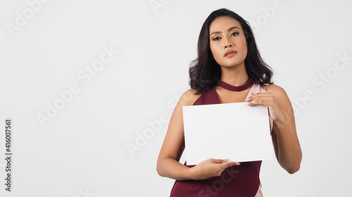 empty blank paper in Asian woman's hand . A studio portrait with white background .Empty Space for text .She have tan skin.