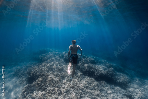 Male free diver glides underwater in clear ocean in Hawaii © artifirsov