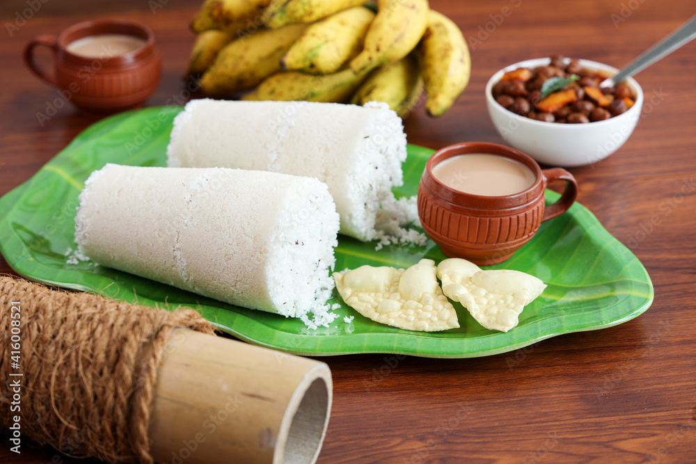 Rice Puttu white Pittu , Kadala Chickpea curry , milk tea , popular South Indian breakfast steamed rice cake Kerala food Tamil Nadu India Sri Lanka. rice flour grated coconut Rice Puttu white Pittu , Kadala Chickpea curry , milk tea , popular South Indian breakfast steamed rice cake Kerala food Tamil Nadu India Sri Lanka. rice flour grated coconut