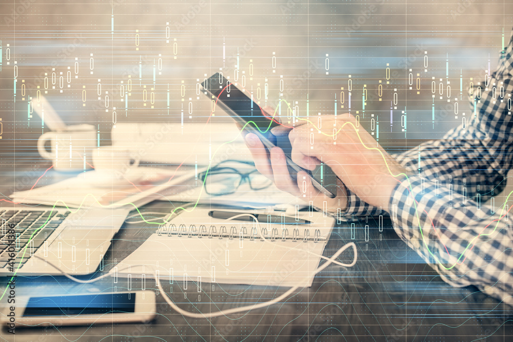 Double exposure of man's hands holding and using a digital device and forex graph drawing. Financial market concept. Double exposure of man's hands holding and using a digital device and forex graph drawing. Financial market concept.