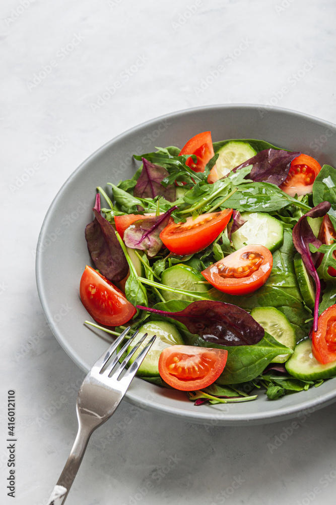 Healthy fresh salad of vegetable cucumber, tomato, spinach, arugula Healthy fresh salad of vegetable cucumber, tomato, spinach, arugula