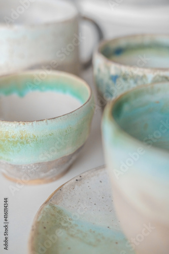 Turquoise handmade cups. Kitchen tea set on a white table. Minimalistic set of dishes