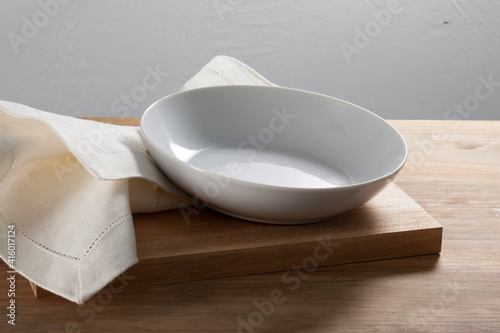 Loza blanca, cuencos bols y platos, sobre mesa de madera,vista cenital. White crockery, bowls and plates, on wooden table, overhead view.