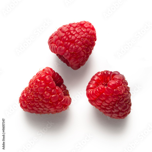 Three little raspberries isolated on white background, with light shadows 
