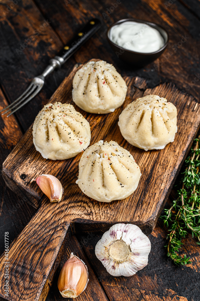 Traditional manti dumplings steamed with mince meat. Dark Wooden background. Top view