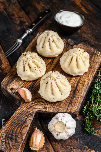 Traditional manti dumplings steamed with mince meat. Dark Wooden background. Top view
