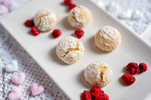 baked low sugar vegan coconut crincle cookies bisquits on a romantic crochet white  table cloth with freeze dried raspberries photo