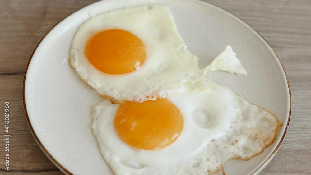 Male hand cutting fried egg with knife and fork. Morning breakfast. Traditional breakfast Male hand cutting fried egg with knife and fork. Morning breakfast. Traditional breakfast
